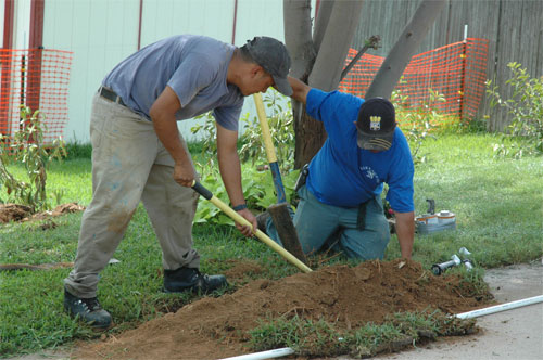 Hurst sprinkler installation team installs a new ground pipe