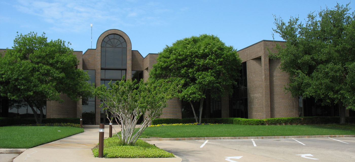 Office complex with lush green lawn and plants in Hurst, Texas